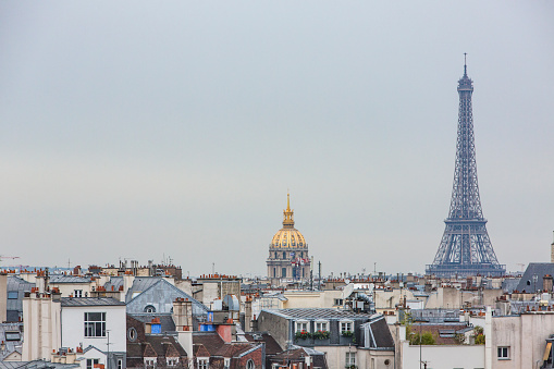 View of Invalides and the Eiffel Tower in Paris over the rooftops of Paris, France at sunset