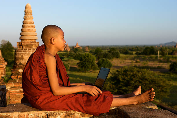 istock Young Buddhist monk resting and using laptop 510697026