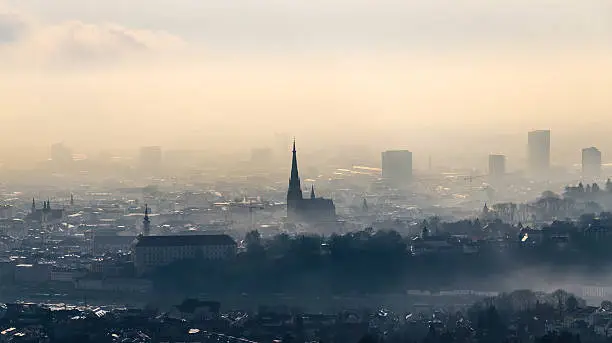Skyline of Linz on a cloudy and misty february morning. Linz is the capital city of Upper Austria and has more than 200.000 citizens. Soft post-processing with professional photo editing software. Photo made outdoor with a D7000 and 16-85mm lens. Low ISO, soft grain.