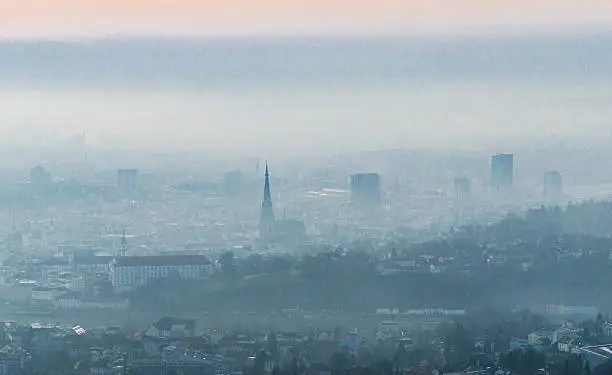 Skyline of Linz on a cloudy and misty february morning. Linz is the capital city of Upper Austria and has more than 200.000 citizens. Soft post-processing with professional photo editing software. Photo made outdoor with a D7000 and 16-85mm lens. Low ISO, soft grain.