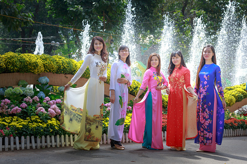 Hochiminh City, Vietnam - February 4, 2016: the young girls wearing traditional dress in a flower festival at Tao Dan Park on the occasion of Lunar New Year in 2016 in the city HoChiMinh.