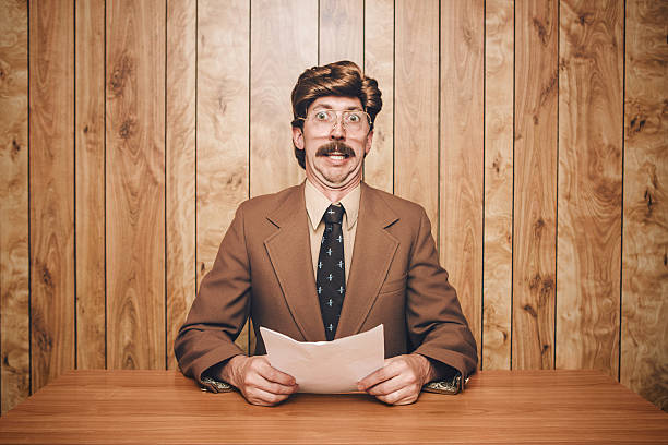 News Anchor Man Retro A 1970's - 1980's style newscaster TV reporter sits in the studio with his script, a stunned look on his face. Styling is very stereotypical of that era; over the top hair, large mustache, and oversized glasses are complimented with brown clothes and wood paneled background. Horizontal with copy space. newscaster stock pictures, royalty-free photos & images