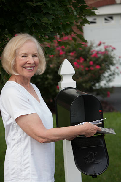 istock Smiling senior woman getting mail from her mailbox 510723165