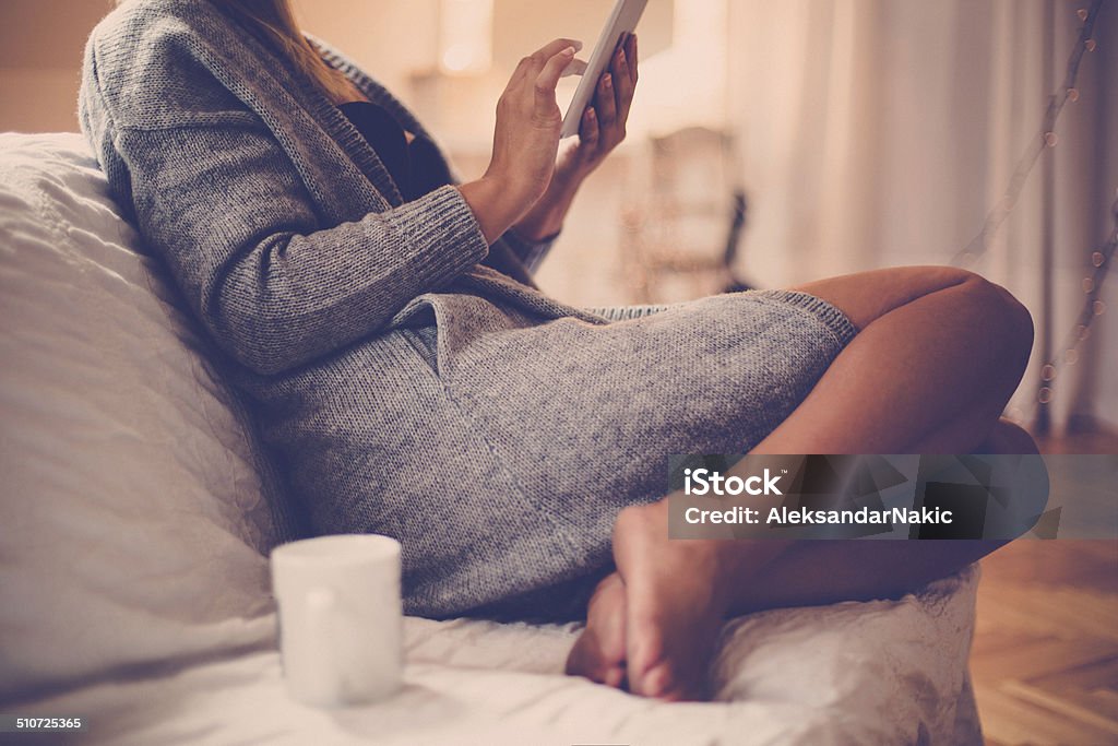 Young woman using a tablet at home Adult Stock Photo