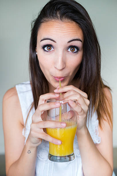 istock Smiling woman drinking orange juice at home. 510725501