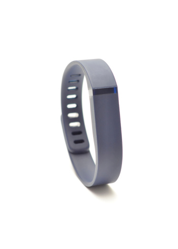Vancouver, BC, Canada -- September 4, 2014:Close up of a Fitbit Flex on a white background with shadows. A Fitbit in a wireless activity and sleep monitor wristband that promotes activity and wellness.