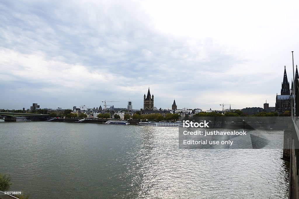 Cologne at morning Cologne, Germany - September 16, 2011: Morning shot over river Rhine in Cologne. At right side is bridge Hohenzollernbrücke and cathedral Kölner Dom. In background is old town with church. At riverside and piers are passenger tourboats. Architecture Stock Photo