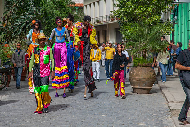 Havana, Cuba - January 2, 2010: Moko Jumbies (Stilt Walkers) parade down a cobblestone street in Old Havana as locals and tourists look on in Havana, Cuba.