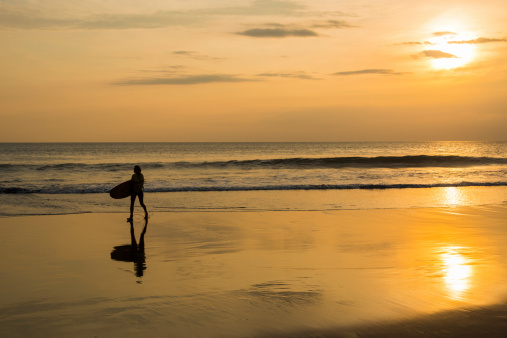 A surfer at the beach after catching waves.