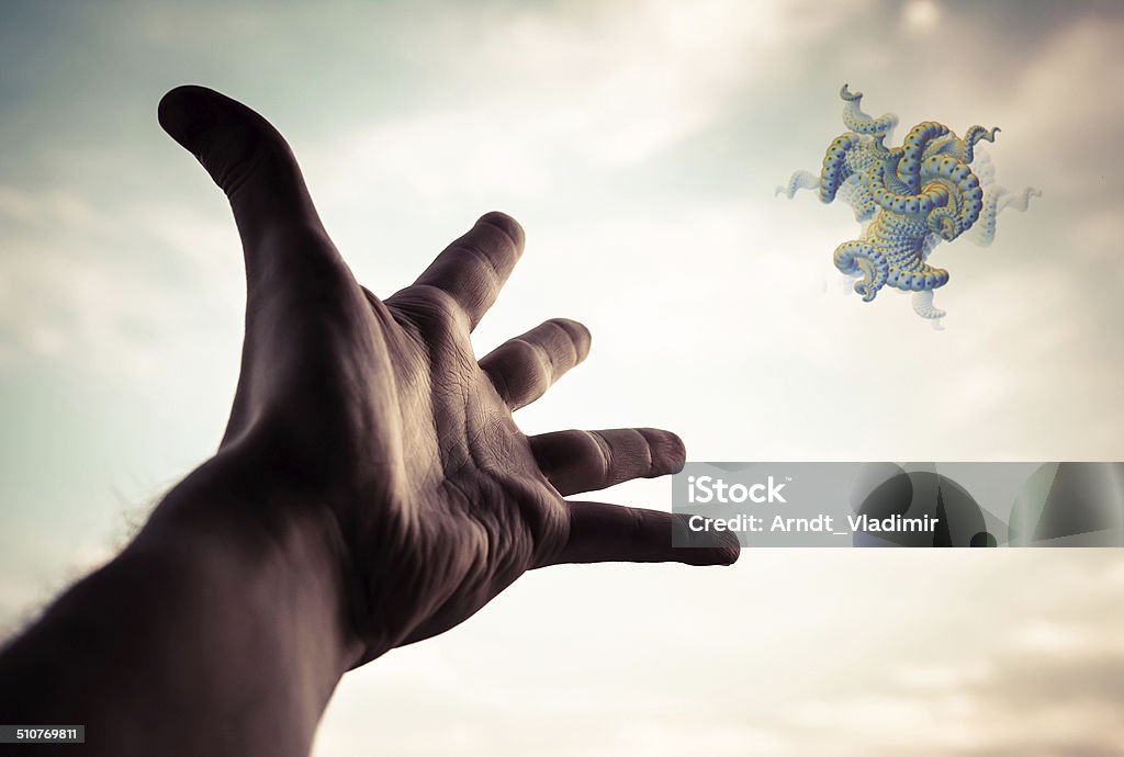 Hand reaching to the fractal figure. Hand of a man reaching to the fractal figure in sky. Conceptual image. Selective focus on hand.  Abstract Stock Photo