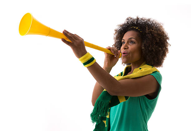 mulher brasileira soprando com vuvuzela em fundo branco - vuvuzela - fotografias e filmes do acervo