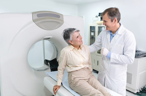 Doctor doing a CAT scan on a senior woman at the hospital - radiology concepts