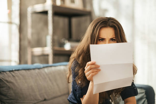istock Concentrated young female is sitting on couch reading letter 510776024