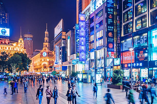 busy Shoppping Street in Shanghai, China Crowds walk below neon signs on Nanjing Road. The street is the main shopping district of the city and one of the world's busiest shopping districts.  jiangsu province photos stock pictures, royalty-free photos & images