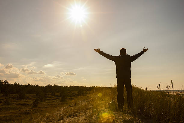 istock Man lifting his hands up silhouette background 510784000