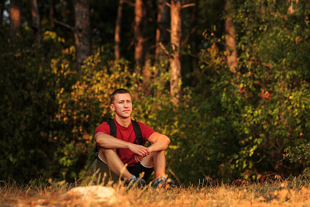 istock Happy hiker man sitting on the ground and looking forward 510789438