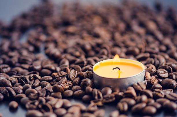 istock Coffee beans on a black background with candle. 510790846