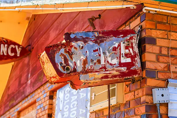 Tucumcari, NM, USA - June 16, 2015: Battered and worn out overhead Office sign