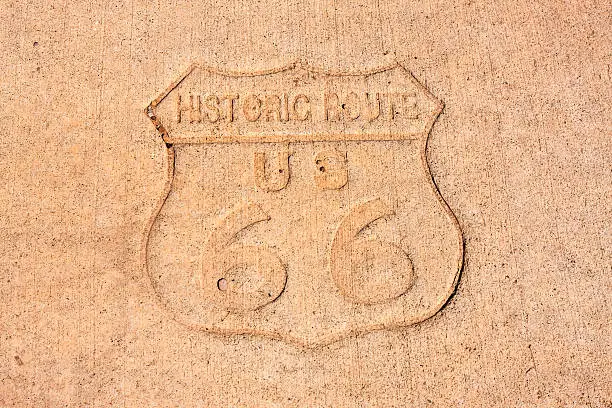 Tucumcari, NM, USA - June 16, 2015: Historic Route US 66 sign impression on the sidewalk in Tucumcari New Mexico