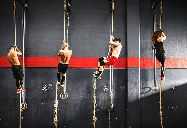 gruppo di atleta sulla corda di arrampicata su una palestra - climbing clambering hanging rope foto e immagini stock