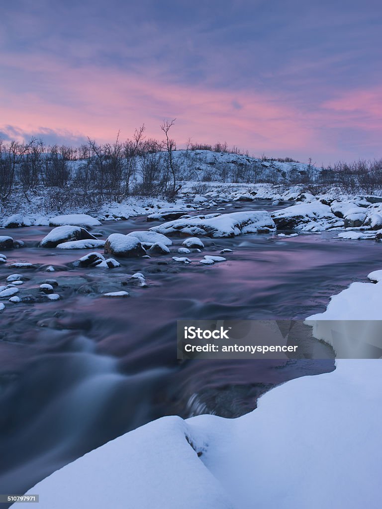 Frozen river runs through arctic tundra in Scandinavia Kilpisjarvi Lake Stock Photo