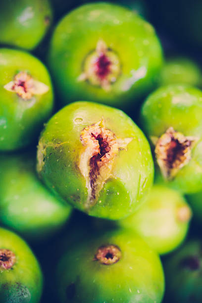 Sliced ripe figs with leaf on a wooden table outdoors