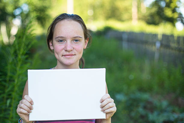 istock Teengirl, outdoors, holding clean white sheet paper 510798557