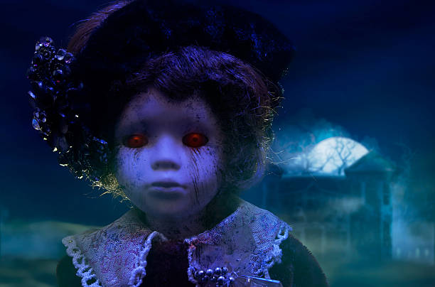 Horror doll with haunted house. Old mystical scary horror doll looking with red demonic eyes with haunted horror house. creepy doll stock pictures, royalty-free photos & images