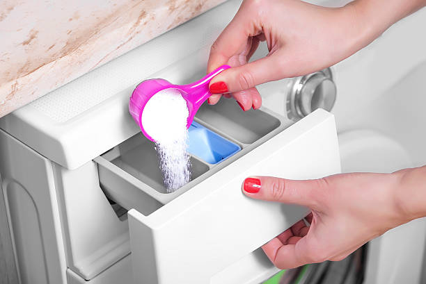 istock Woman throws laundry detergent into the washing machine 510799668