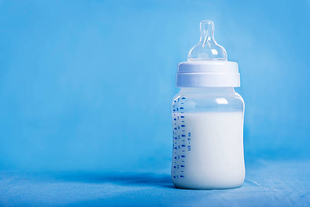 istock Baby bottle with milk on a blue sheet 510800904