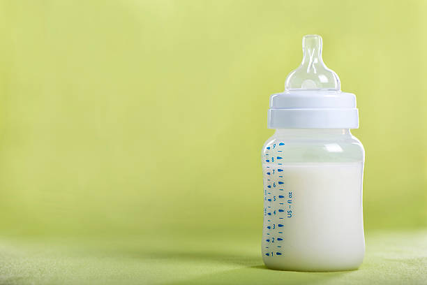istock Baby bottle with milk on a green sheet 510801046