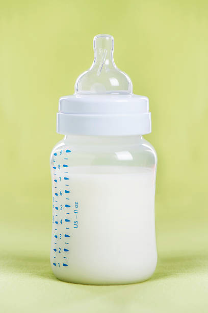 istock Baby bottle with milk on a green sheet 510801102
