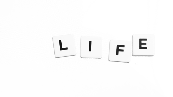 word Life written with loosely arranged tiles on an isolated background.