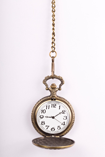 Close-up of a vintage pocket watch with chain representing the concept of time is money.