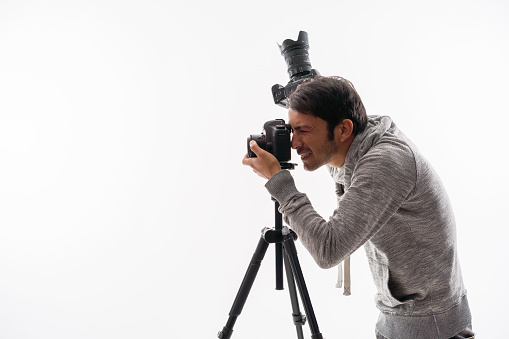 Photographer with camera and tripod, isolated on white,studio light