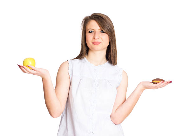istock girl with apple and cookie tempted 510802276