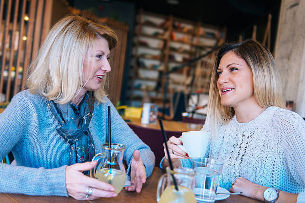 istock Mature and young woman having coffee time in modern cafe 510802946
