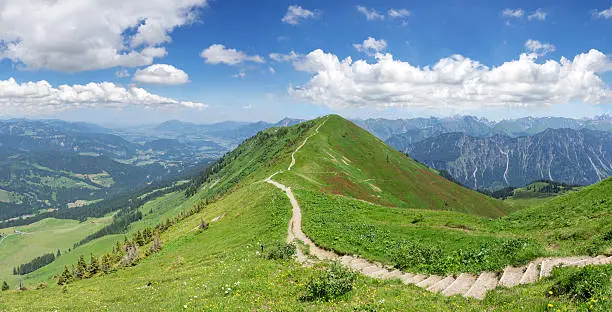 Hiking trail in the mountain landscape of the Allgau Alps on the Fellhorn ridge from the Fellhorn towards Soellereck. On the left below is the valley Kleinwalsertal, Austria. 