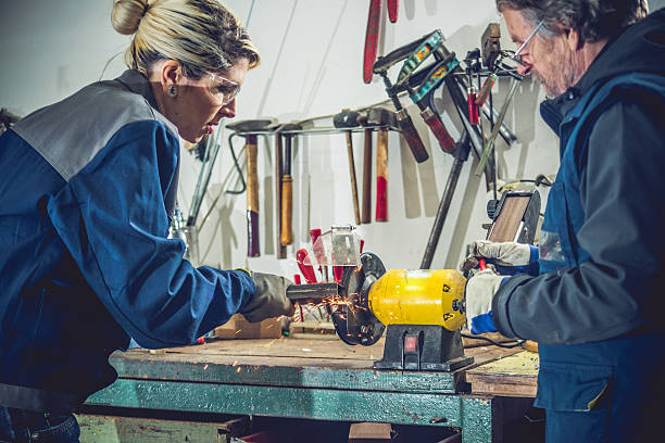 istock Young Woman While Grinding Metal in Garage or Mechanical Workshop 510844466