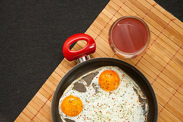 две жареные яйца на сковороде черный с соком - oklahoma house red residential structure стоковые фото и изображения