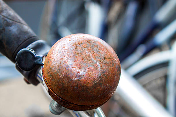 A rusty metal bicycle bell on a bike handle