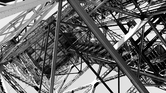 Cable car steel tower from below looking up. High contast black and white architecture with stairs with deminishing focus.