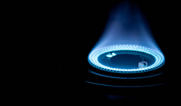 Blue flames from burner - Stock Image Blue flames from gas stove burner. Closeup shot of blue flames from a kitchen gas range gas stove burner photos stock pictures, royalty-free photos & images