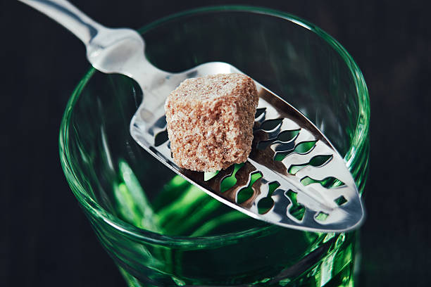 Absinthe With Spoon and Sugar Cube Glass of absinthe with an absinthe spoon and sugar cube. This is before the water is poured. absinthe spoon stock pictures, royalty-free photos & images
