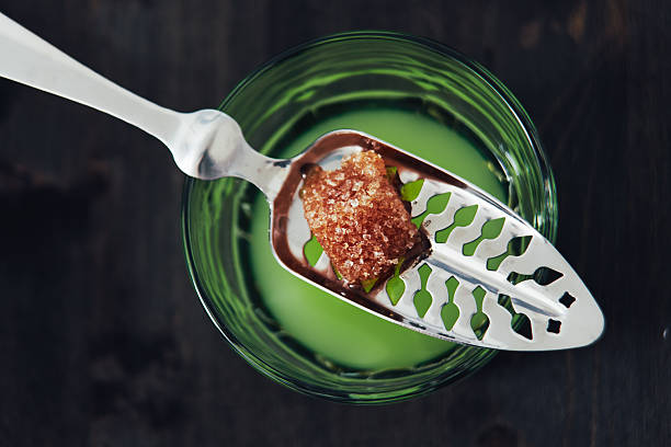 Absinthe With Spoon and Sugar Cube Glass of absinthe with water poured over a sugar cube. Includes absinthe spoon. absinthe spoon stock pictures, royalty-free photos & images