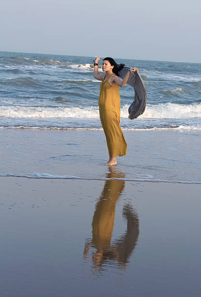 istock Woman walking along the beach 510851907