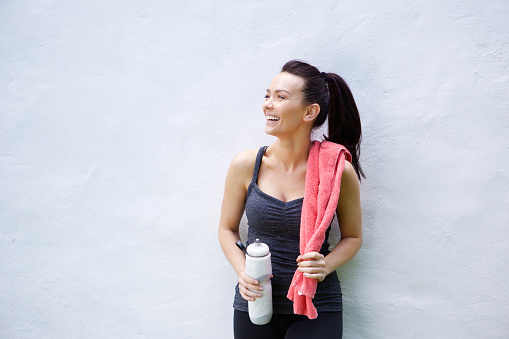 Sonriendo deportivo mujer con botella de agua y toalla photo
