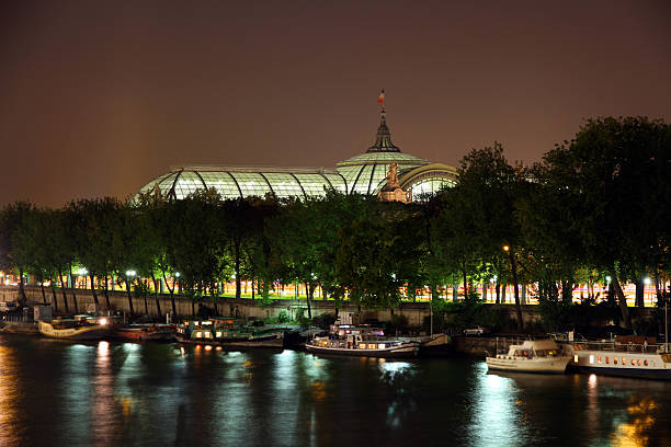 Paris, France - September 24, 2013: The Grand Palais in Paris at night. The Grand Palais des Champs-Elysées is a large exhibition hall and museum complex located at the Champs-Élysées in the 8th arrondissement of Paris. It was built in 1897as part of the preparation works for the Universal Exposition of 1900, which also included the creation of the adjacent Petit Palais and Pont Alexandre III.