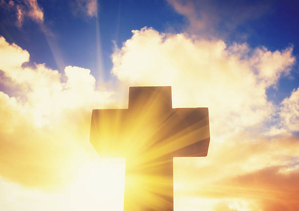 istock Silhouetted stone cross with sunbeam breaking through clouds 510853822