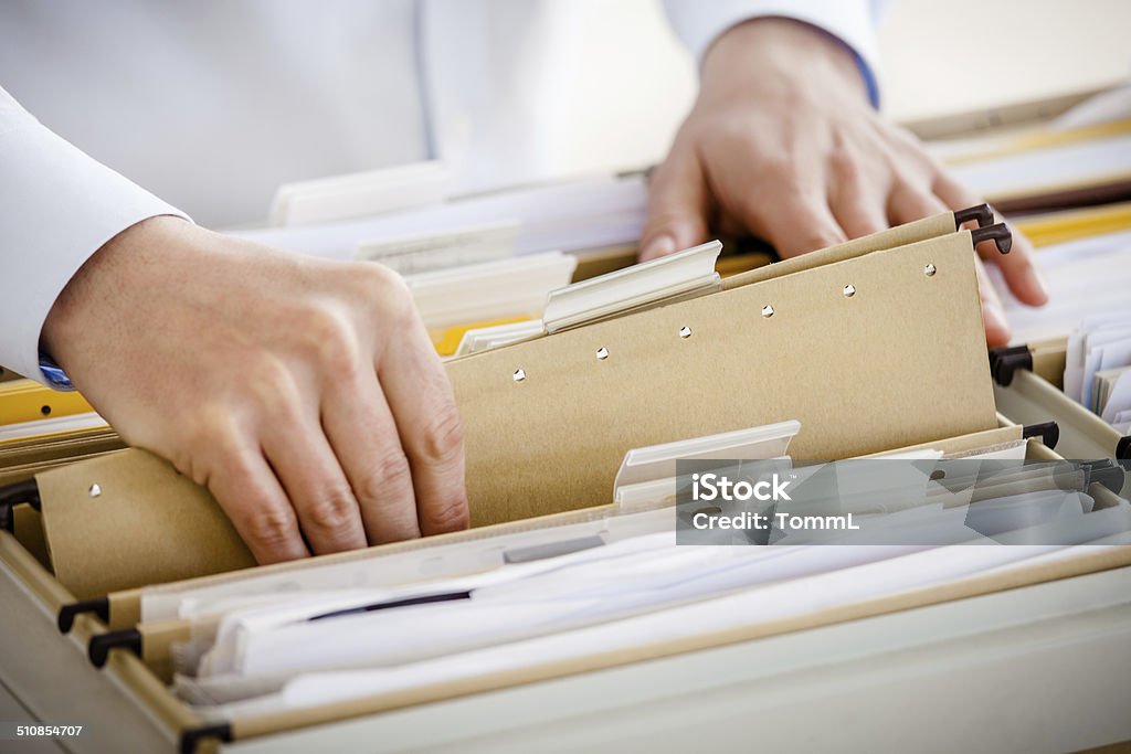 Filing In File Cabinet Close-up of hands searching in a file cabinet Filing Documents Stock Photo